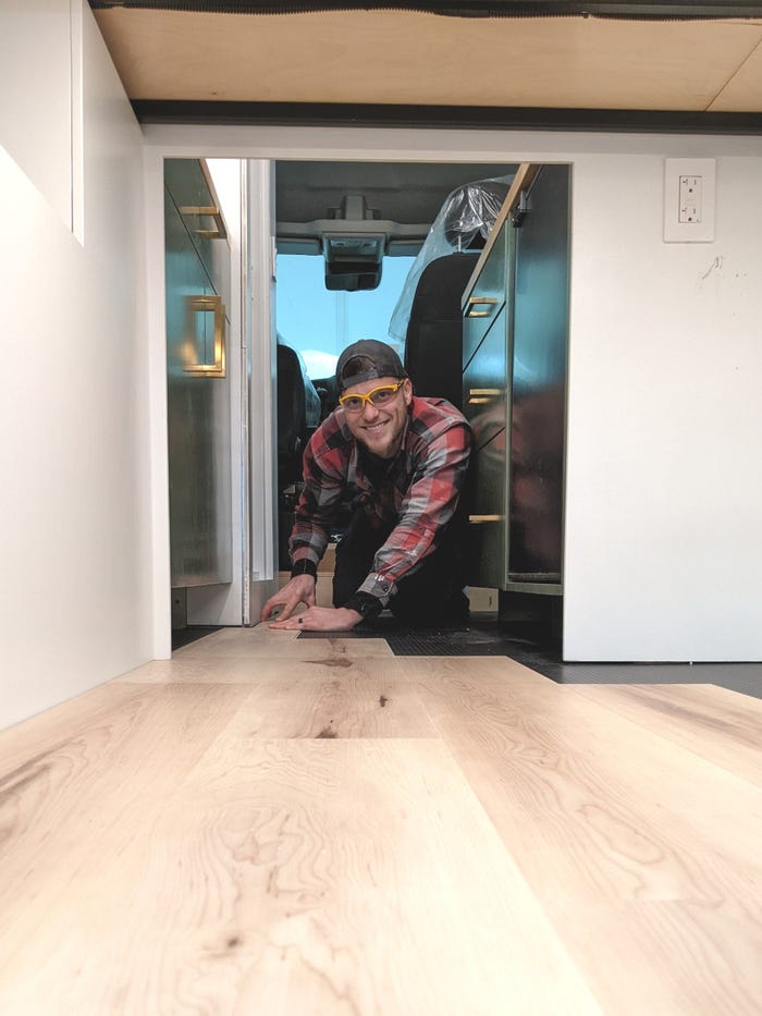 Reid installing flooring in the original van